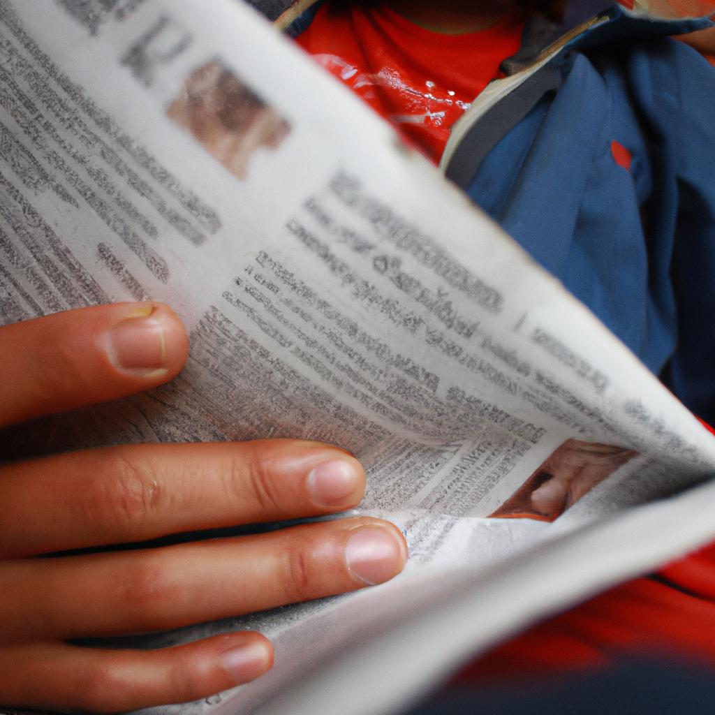 Person holding a newspaper, reading